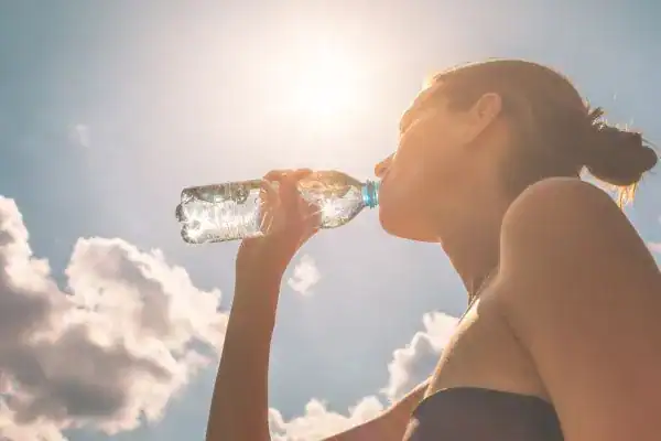 Hydration: The Secret Ingredient for a Toned Stomach and Enhanced Fitness 3 Image of woman drinking water to hydrate Rugby after run.